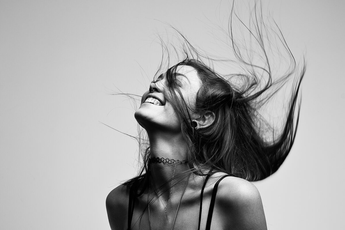 Portrait studio en noir et blanc, cheveux en mouvement, énergie capturée par Luca Struglia