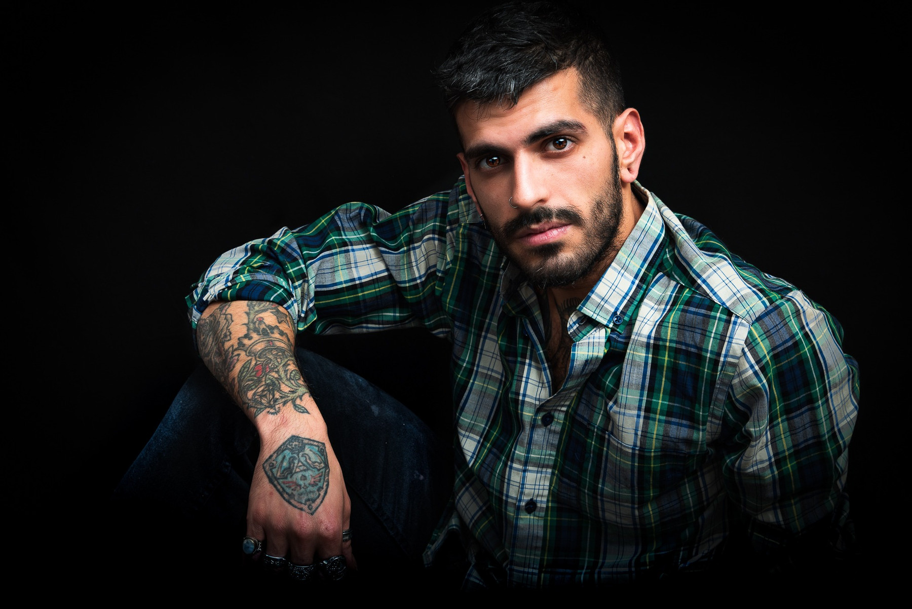 Portrait studio d'un homme à la chemise à carreaux sur fond noir