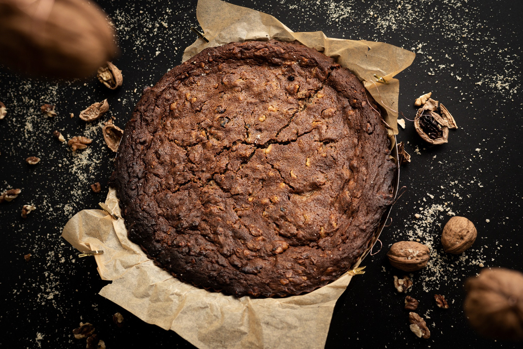Gâteau au chocolat et aux noix vu du dessus sur fond noir