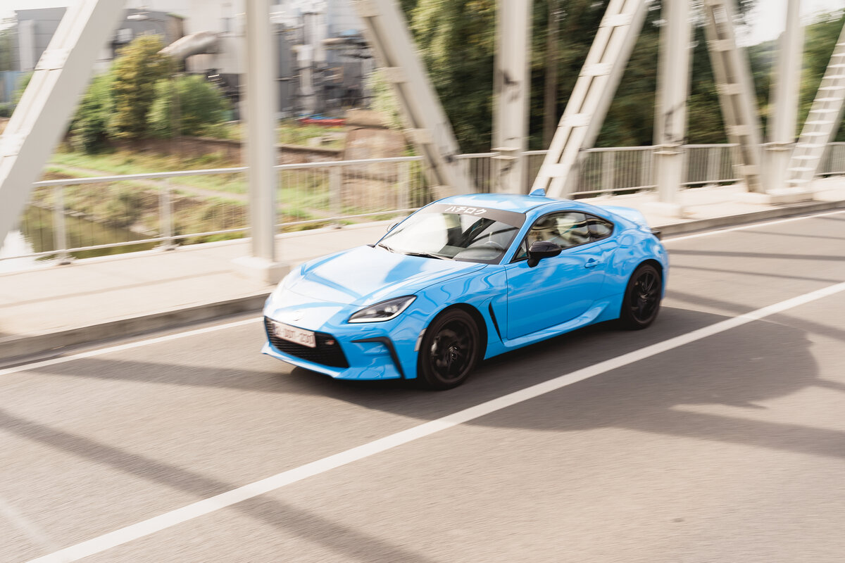 Voiture sportive bleue en mouvement sur un pont, image de marque par Luca Struglia